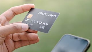 A credit card held above a phone