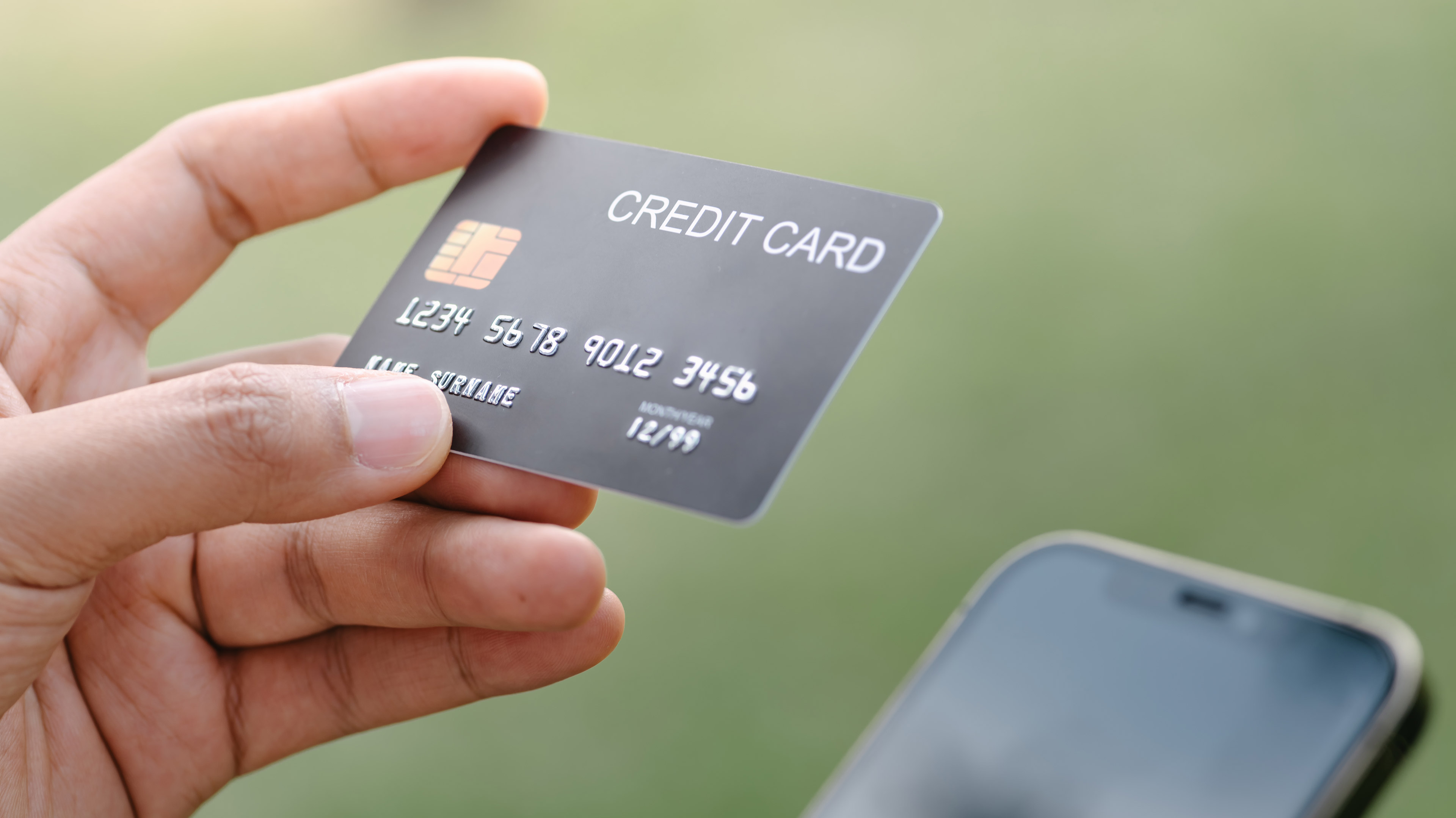 A credit card held above a phone