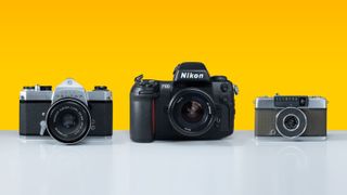 Three of the best film cameras sitting on a grey surface