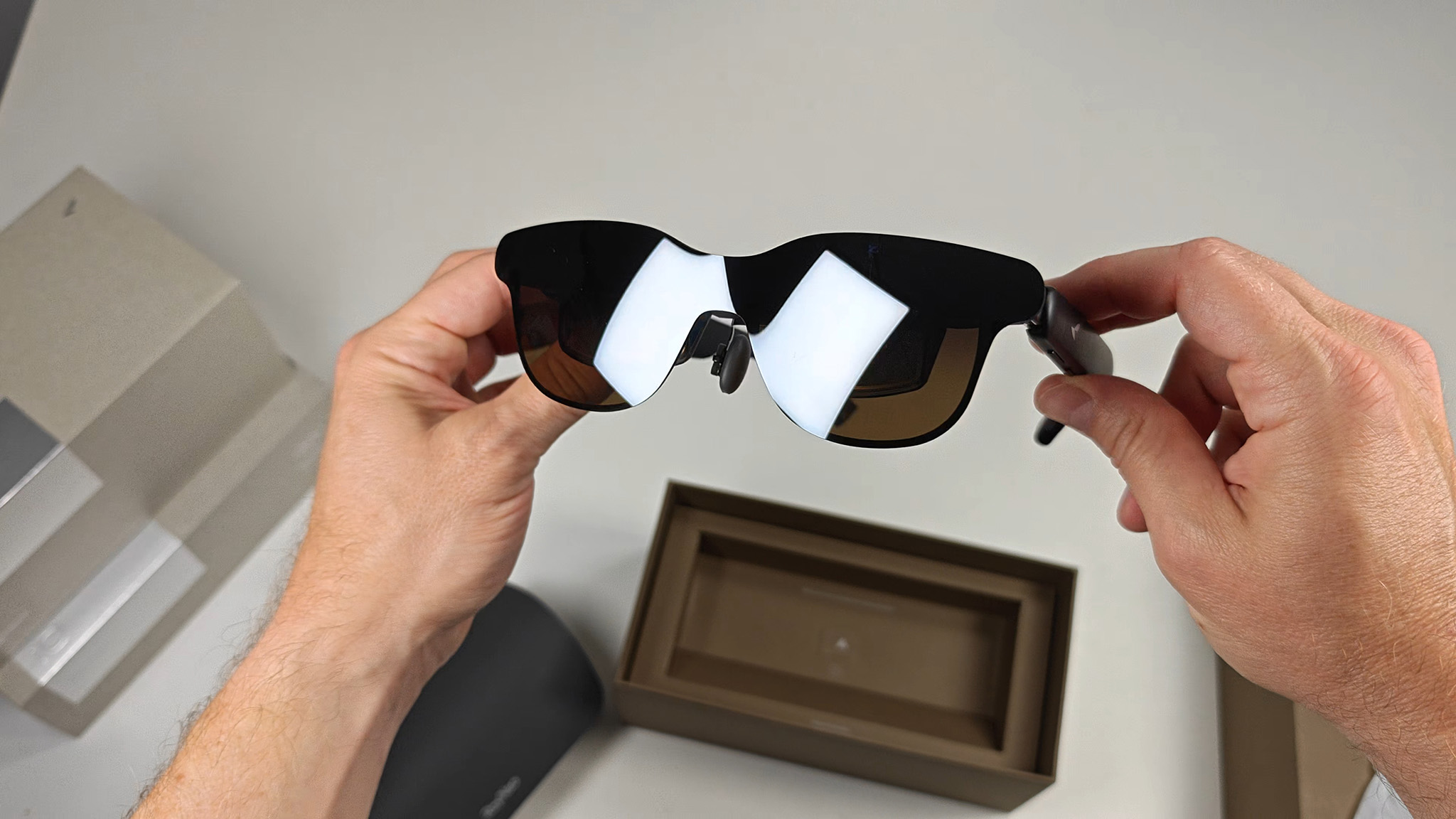 Holding a pair of RayNeo GT smart glasses