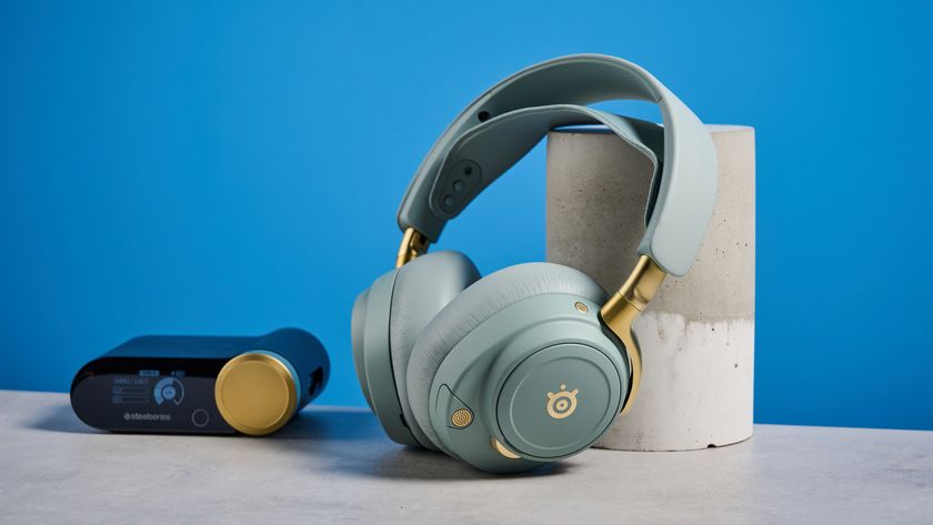 The SteelSeries Arctis Nova Elite with its USB hub on a stone surface with a blue background