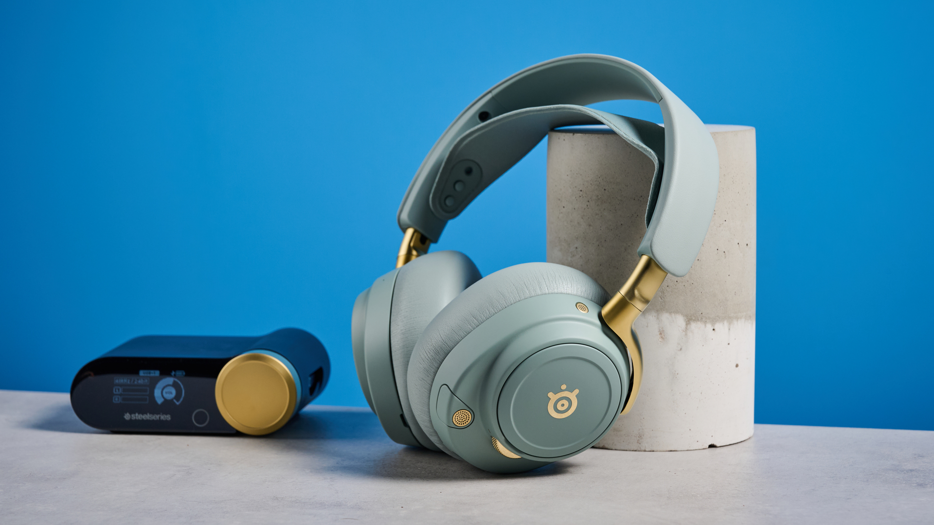 The SteelSeries Arctis Nova Elite with its USB hub on a stone surface with a blue background