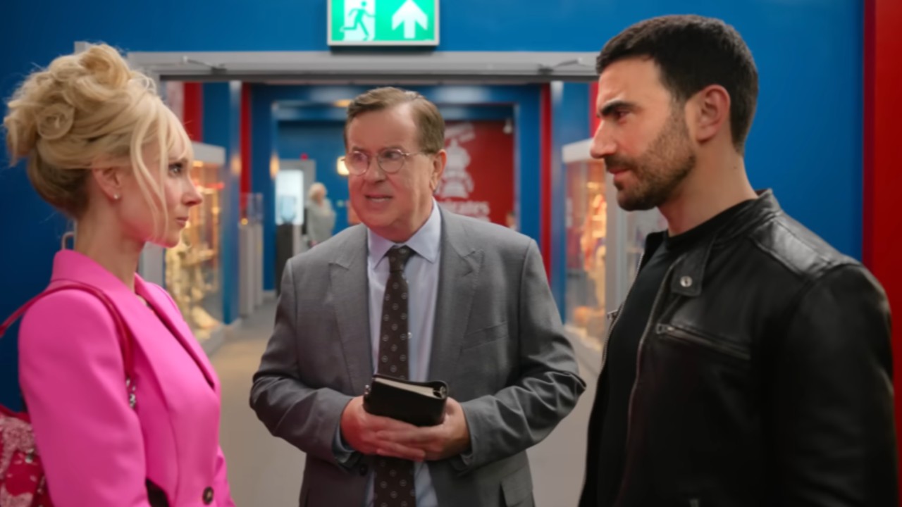 From left to right: Keeley is looking at Roy, Higgins is standing between them looking confused and Roy is standing to the right looking at Keeley.