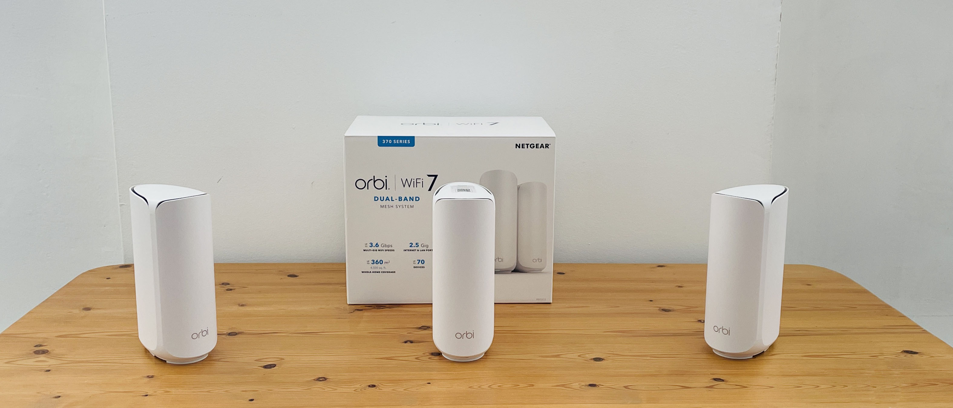 Netgear Orbi 373 with one router and two satellites on a wooden table