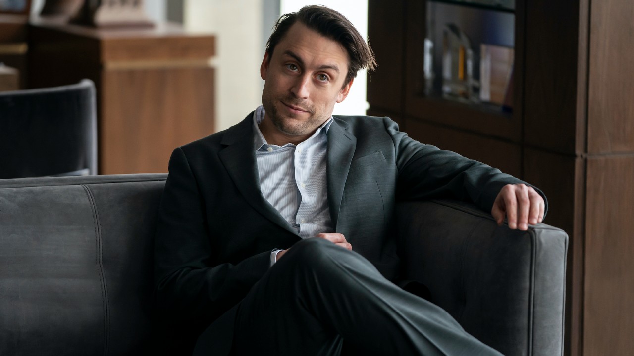 Kieran Culkin crossing his legs in Succession. 