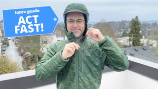 Writer Dan Bracaglia wearing a green L.L. Bean PrimaLoft Hooded jacket on a roof with clouds in the distance