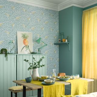 Dining room with green painted wall, yellow curtains and green and yellow wallpaper