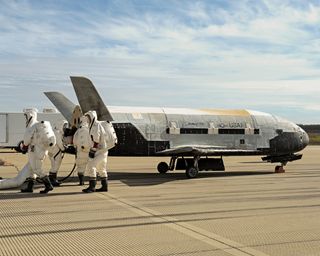 Recovery crewmembers process the X-37B Orbital Test Vehicle at Vandenberg Air Force Base in California after the robotic space plane touched down in October 2014.