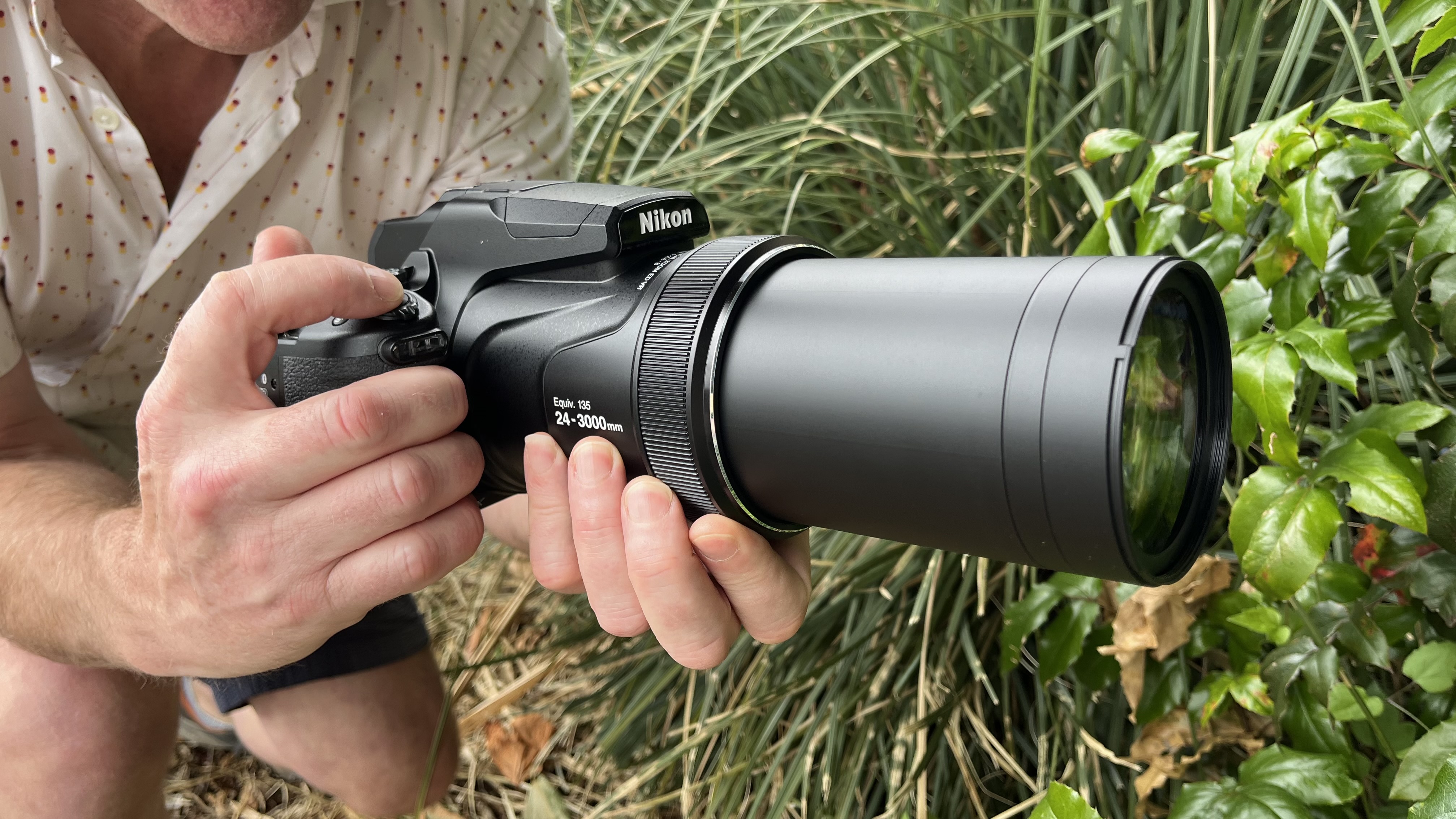 Nikon Coolpix P1100 lifestyle image of Adam Waring holding the camera next to vegetation