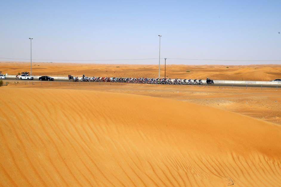 The peloton passes through the desert