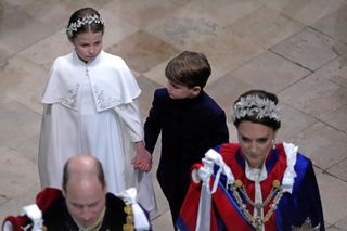 Princess Charlotte and Prince Louis hold hands following the Coronation of King Charles III and Queen Camilla at Westminster Abbey on May 6, 2023 in London, England