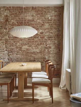 dining room with brown furniture and brick wall