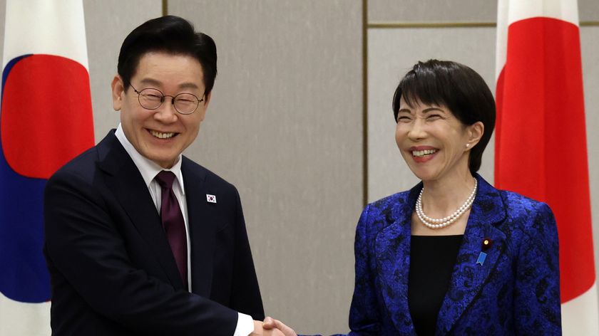 Japanese Prime Minister Sanae Takaichi (R) shakes hands with South Korean President Lee Jae Myung