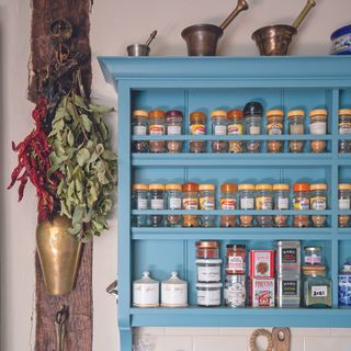Rustic kitchen with blue spice rack.