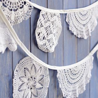 blue wooden wall with white lace cloth bunting