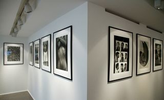 image captured from the corner room of an exhibition showing the frames images on a wall of an angle.