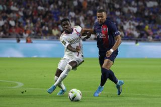 Ernest Nuamah Appiah of Olympique Lyon tussles with Kylian Mbappe of PSG during the Ligue 1 Uber Eats match between Olympique Lyonnais and Paris Saint-Germain at Groupama Stadium on September 03, 2023 in Lyon, France.