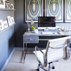 a home office with art work on the walls and narrow picture ledges with a collection of frames