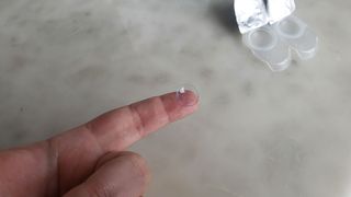 Image shows a GlassesUSA.com Vista plus contact lens on someone's finger.