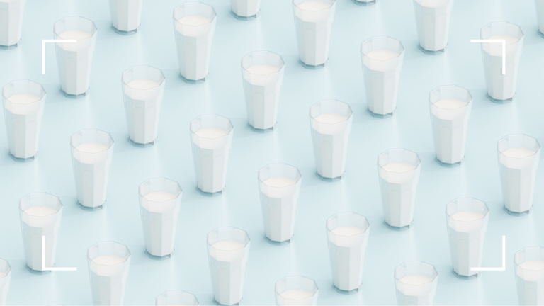 multiple glasses of milk on blue background
