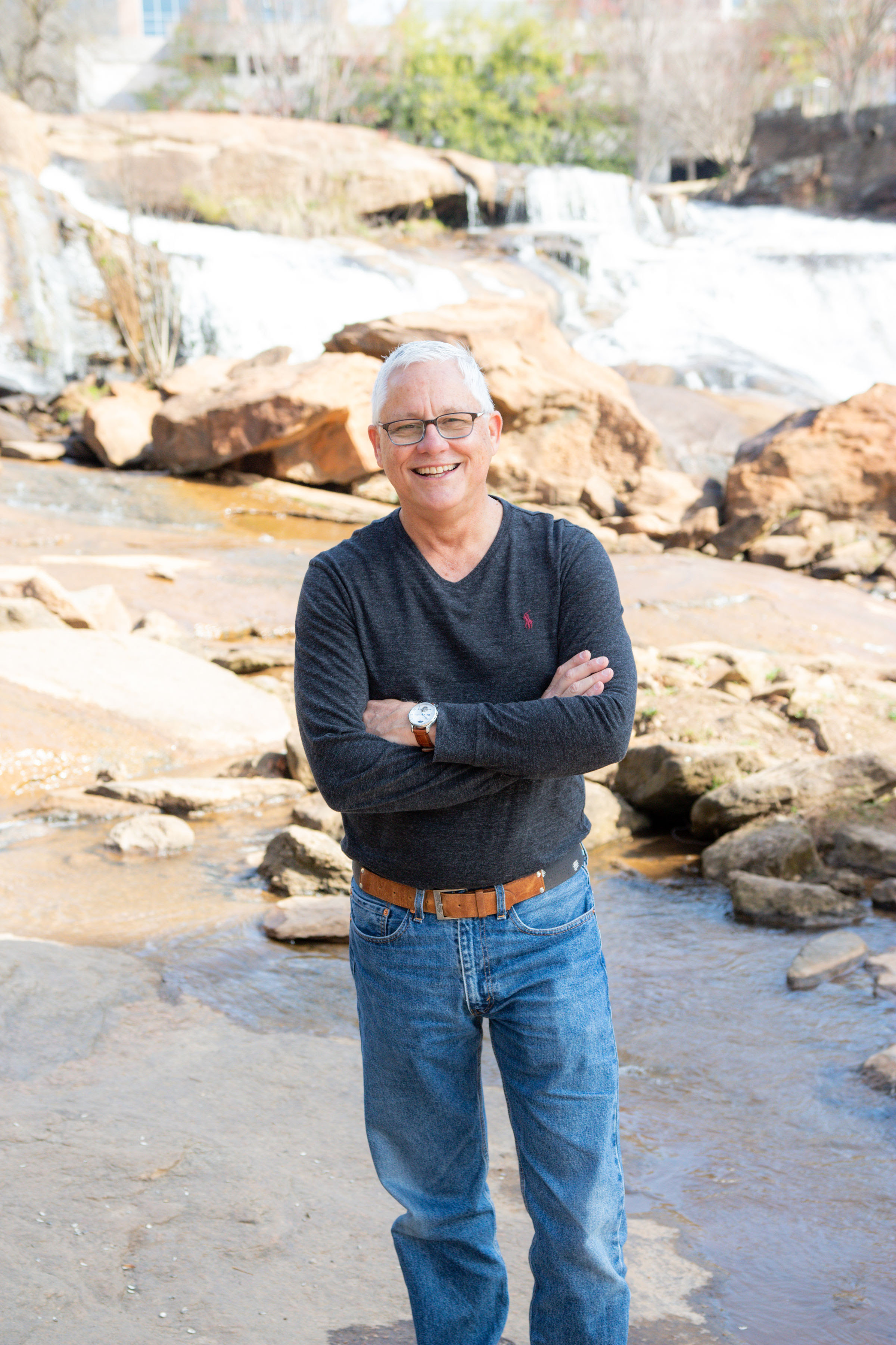 Smiling headshot of Brightline executive in front of a waterfall and rocks.