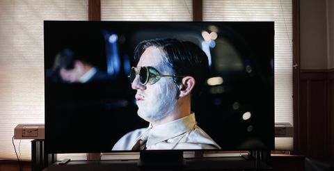 TCL QM851G TV showing image of man wearing sunglasses