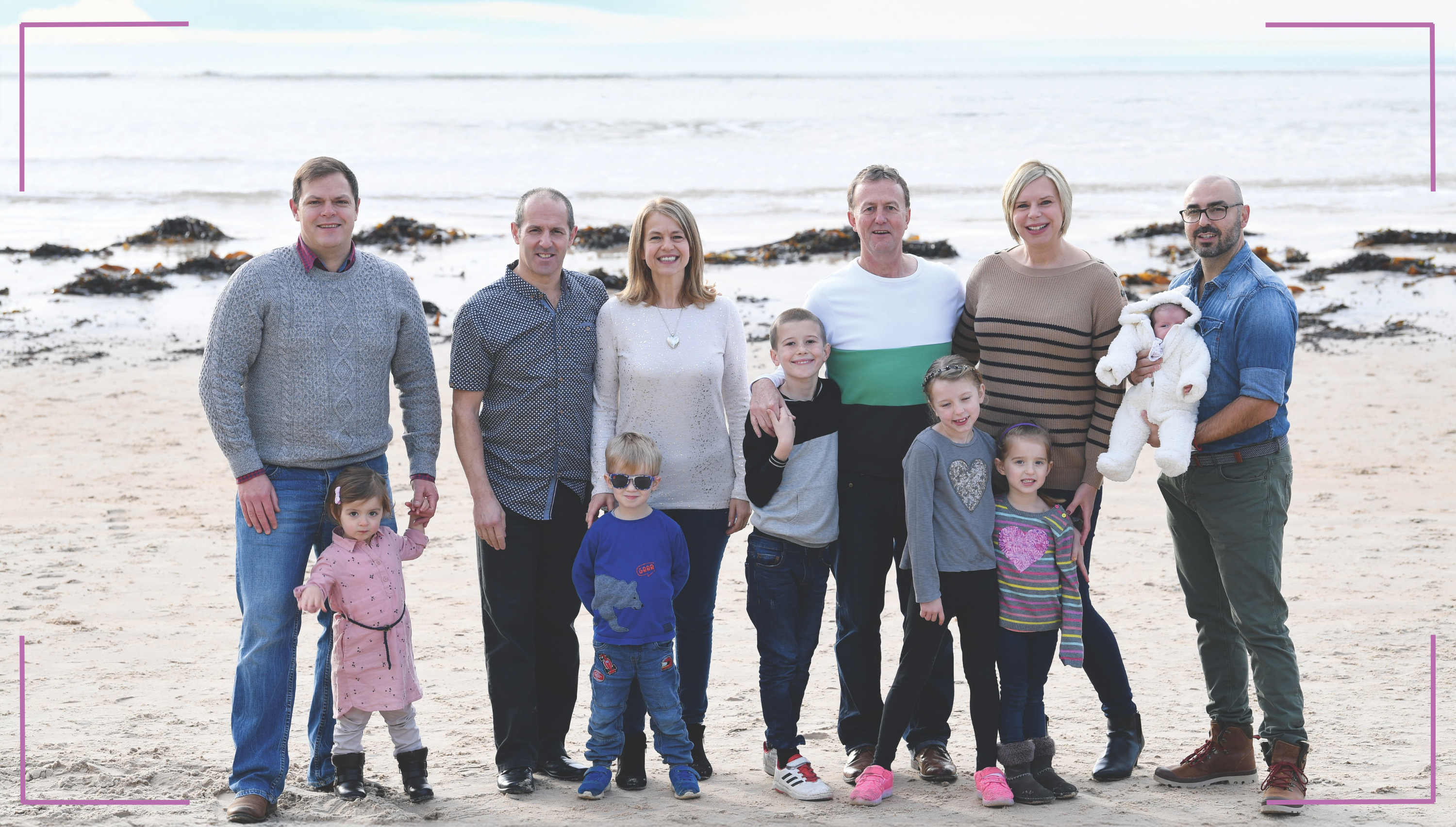 Surrogate Karina Ward with families at St Brelades Beach in Jersey. From left: Dan, Isabella, Paul, Sue, Luca, Jayden, Tim, Kayla, Karina, Lydia, baby Sophie, Hilario