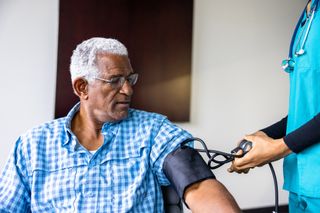 A man gets his blood pressure taken at the doctor.
