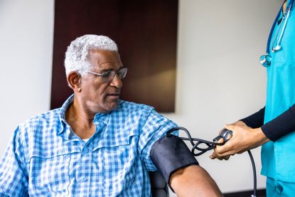 A man gets his blood pressure taken at the doctor.