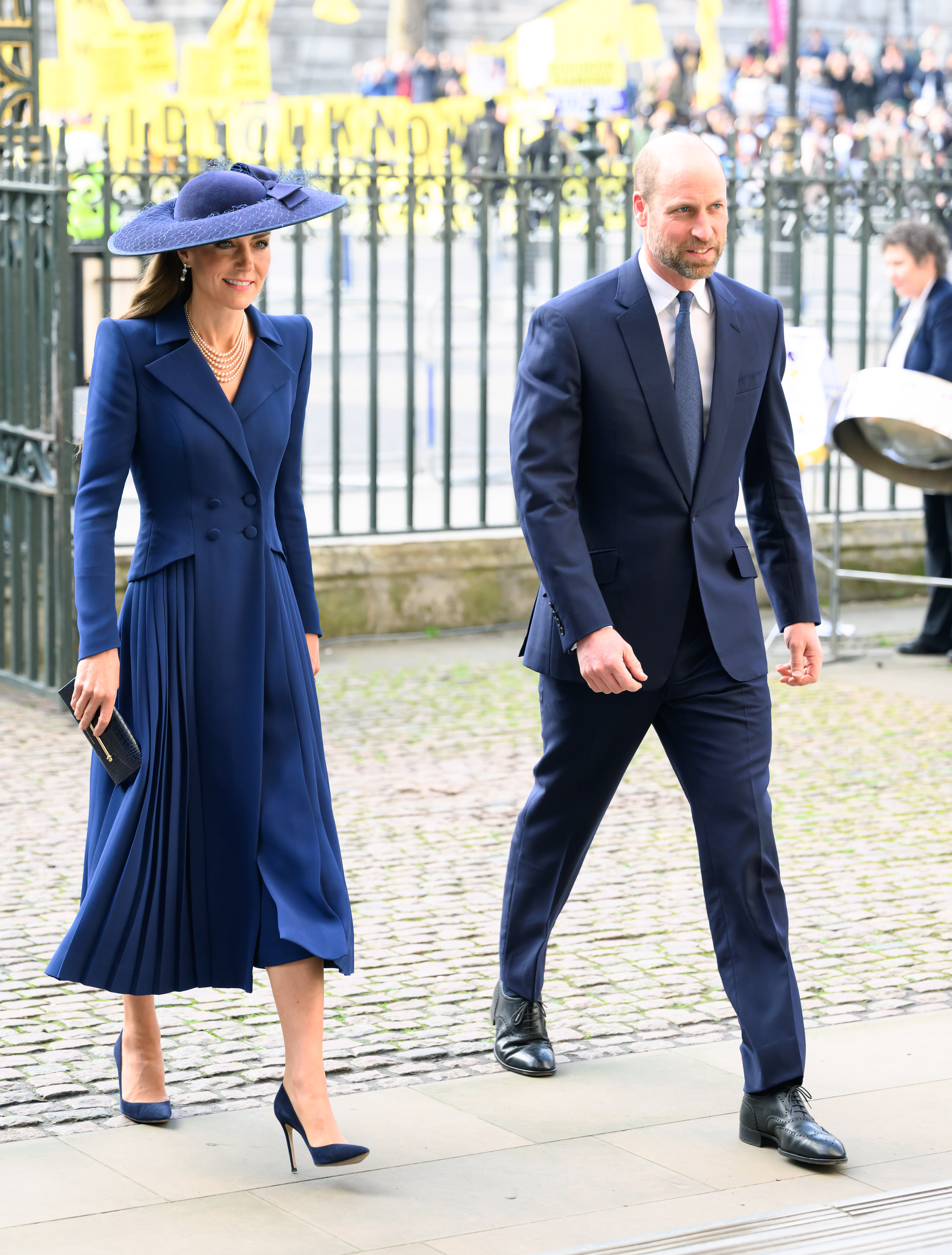 Princess Kate wearing a blue coat and hat walking next to Prince William at Commonwealth Day