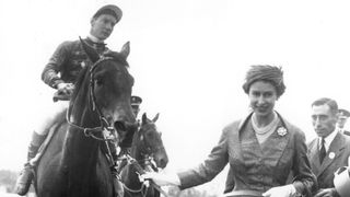 Queen Elizabeth II leads in her first classic winner, Carrozza, after the filly's victory in the Oaks at Epsom.