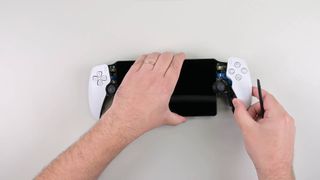 Ifixit PlayStation Portal teardown screenshot of hands removing face places