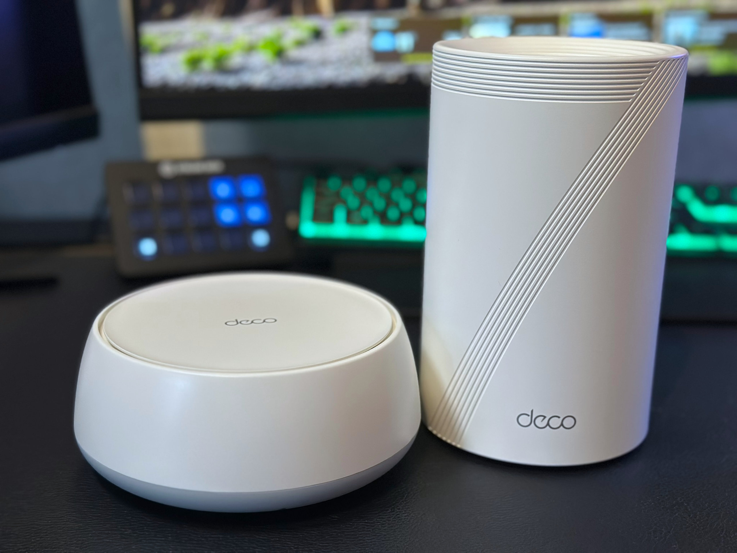 A photo showing the size comparison of a TP-Link Deco BE25 (left) and Deco BE68 (right).