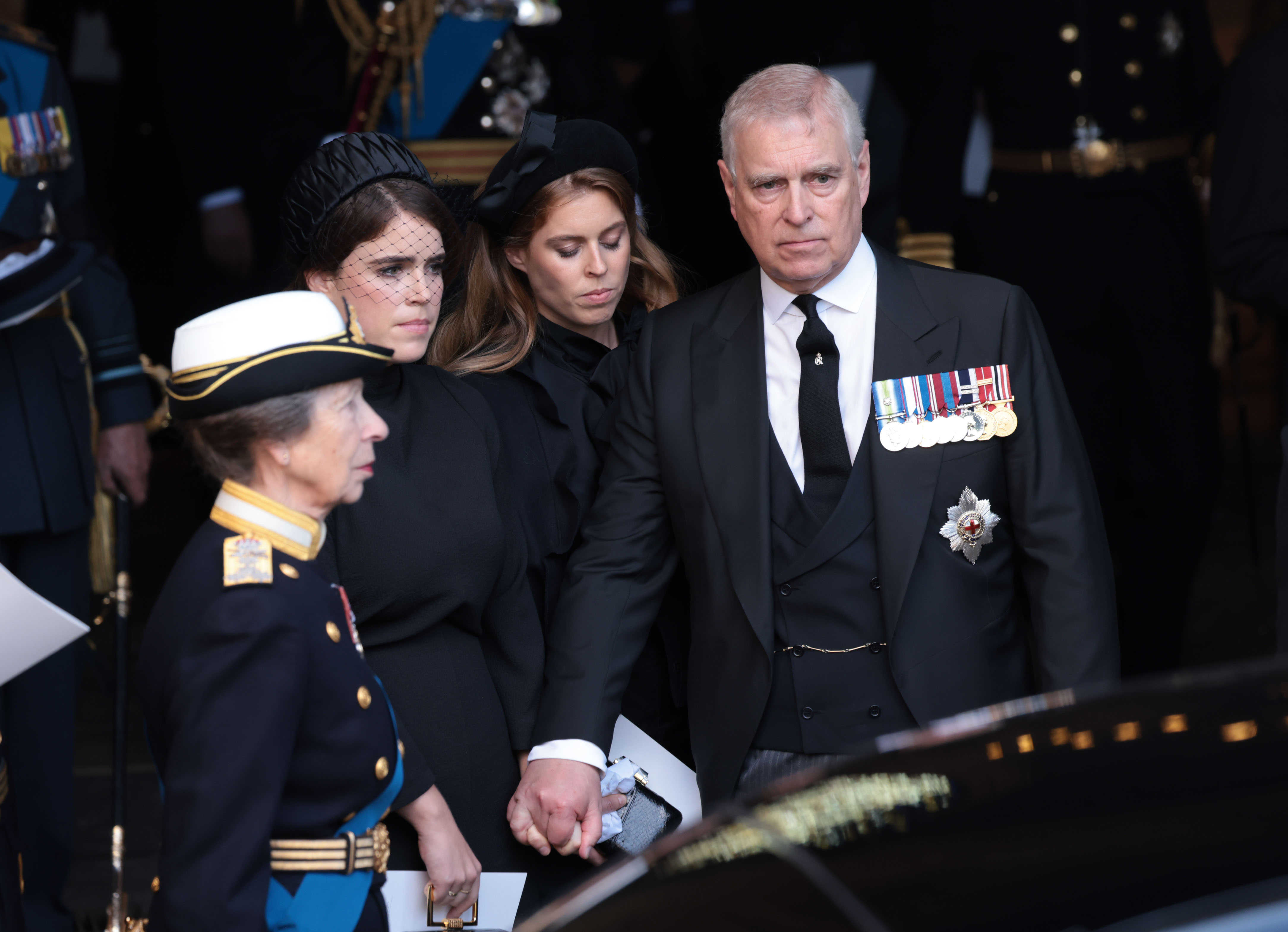 Prince Andrew holding hands with his daughters Eugenie and Beatrice at a memorial for Queen Elizabeth