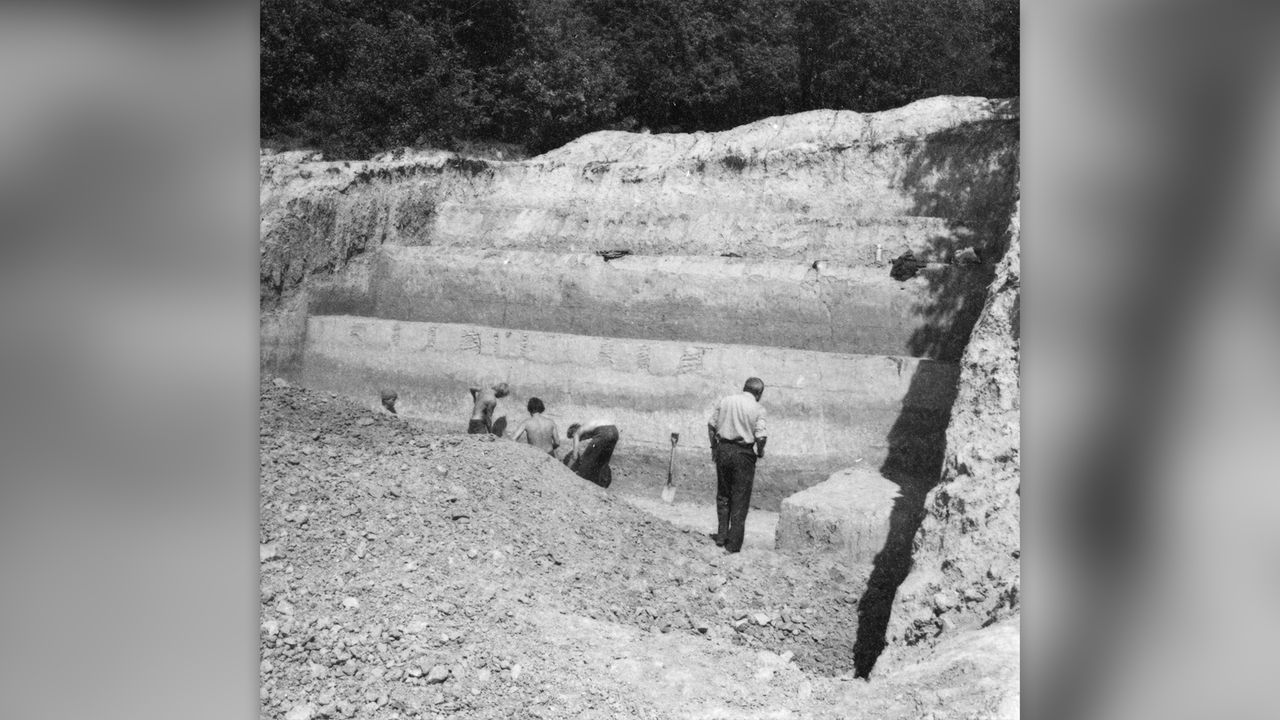 Photo from 1984 (black and white) showing three people at the excavation site.