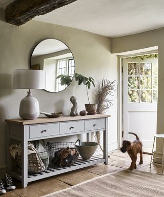 A hallway shoe storage idea with baskets under a console table