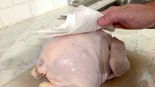 Turkey being patted down with paper towels