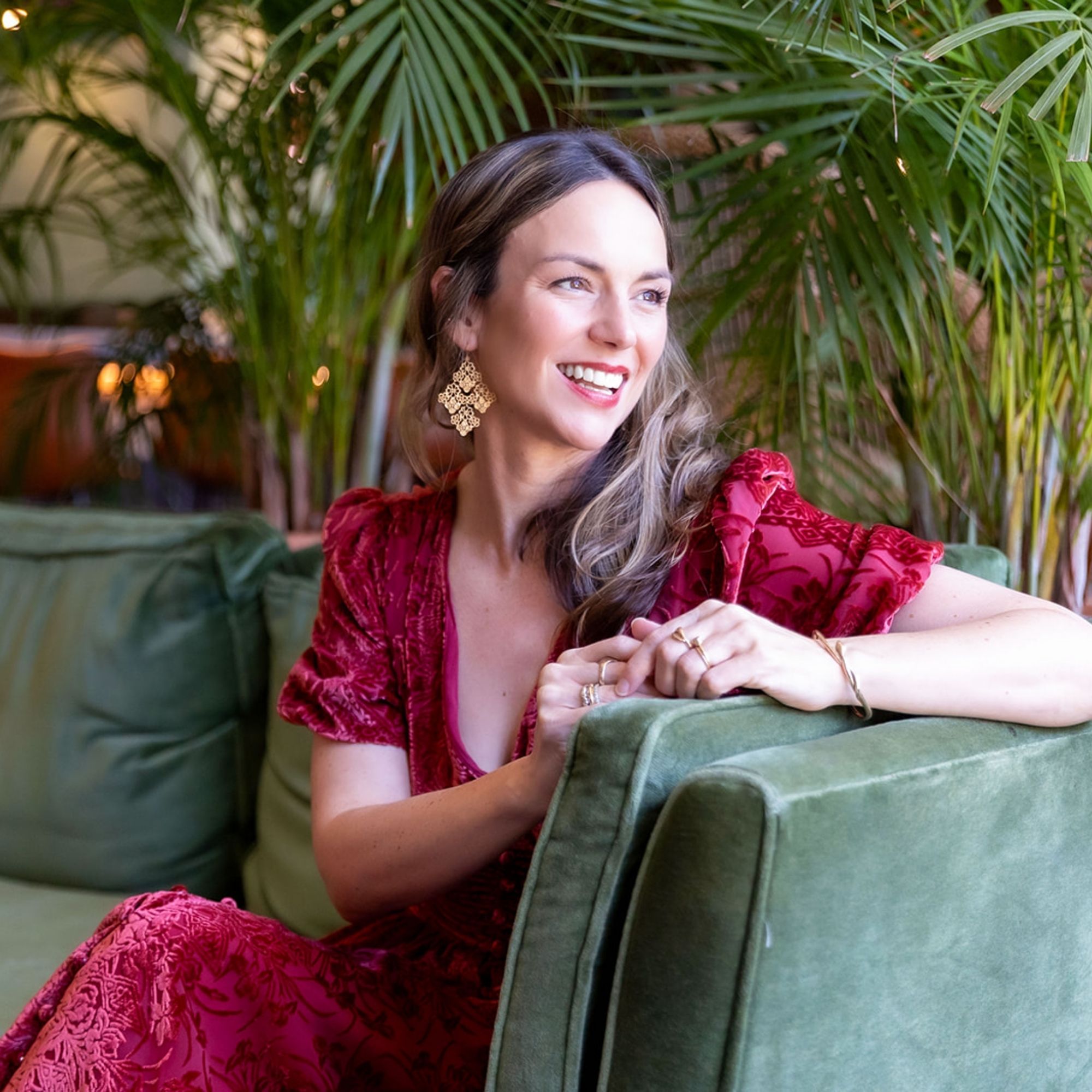 A headshot of Michelle Simmons on a green velvet couch