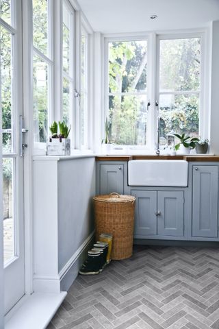 boot room in glazed porch with herringbone flooring and butlers sink