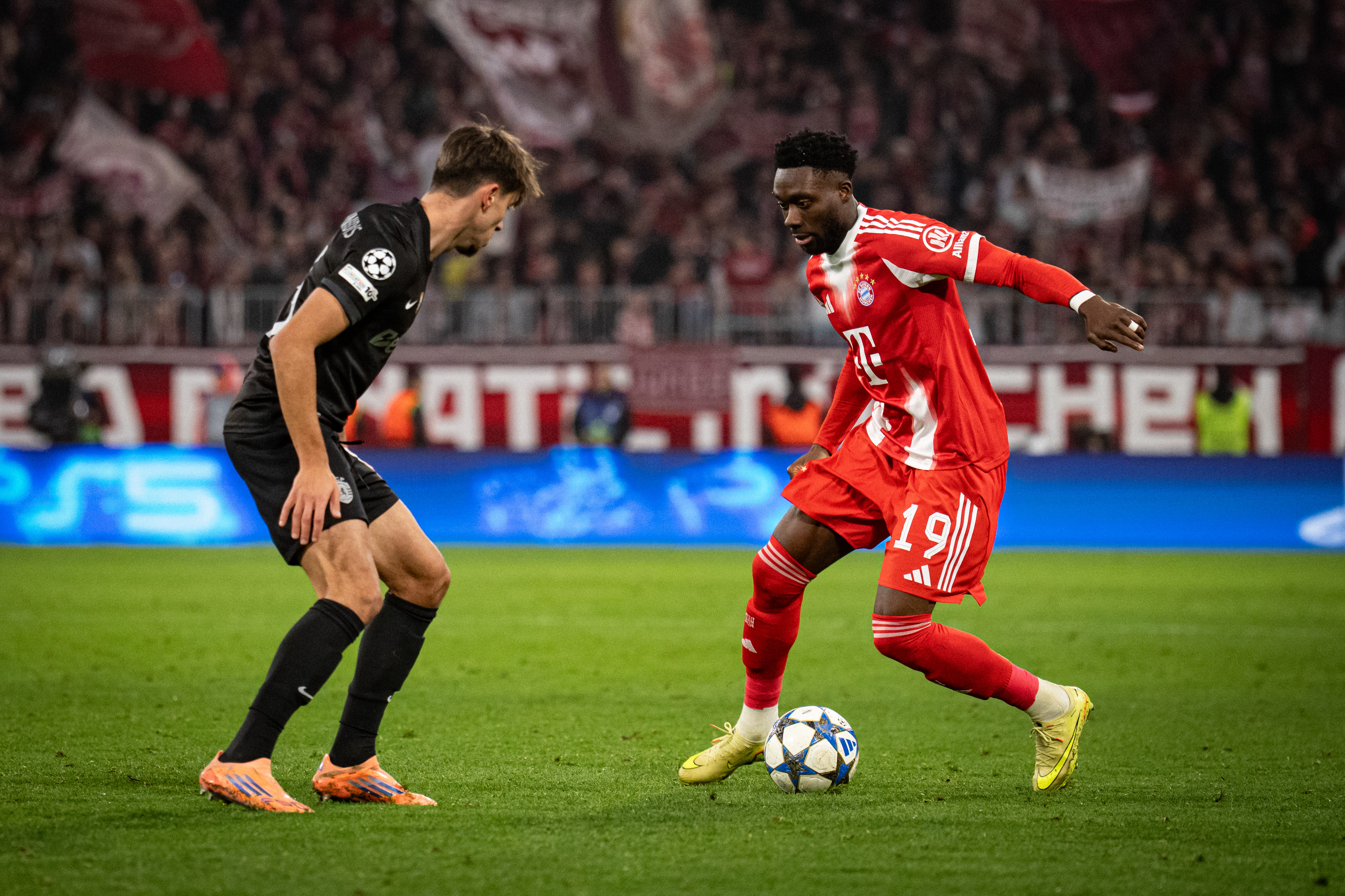 Alphonso Davies of FC Bayern Muenchen dribbles the ball during the UEFA Champions League 2025/26 League Phase MD6 match between FC Bayern M&amp;uuml;nchen and Sporting Clube de Portugal at Football Arena Munich on December 09, 2025 in Munich, Germany.