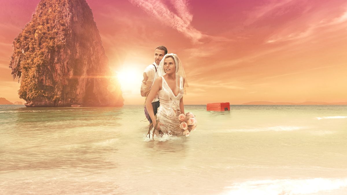 Stranded on Honeymoon Island - couple standing in the sea wearing wedding outfits 