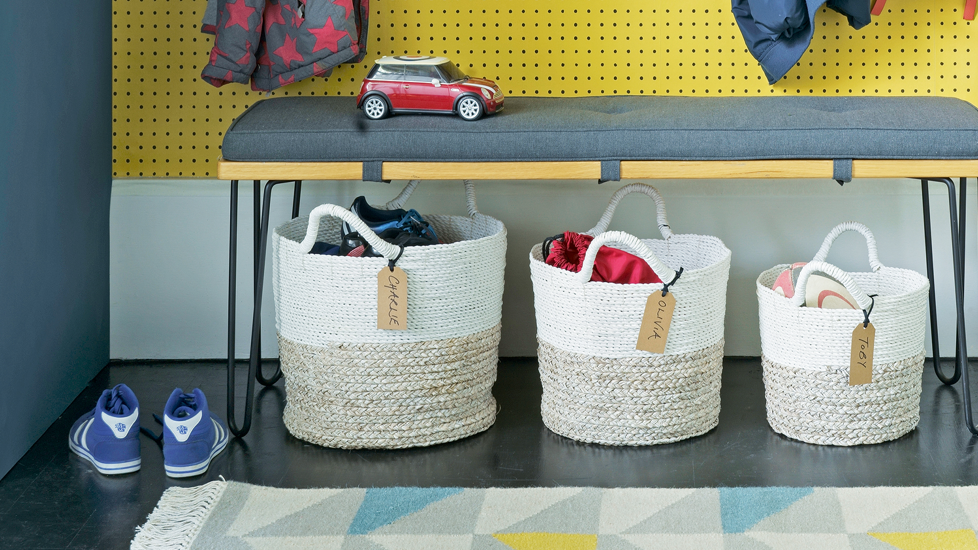 blue and yellow hallway with labelled baskets for storing accessories