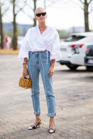 woman wearing a white shirt and blue straight leg jeans