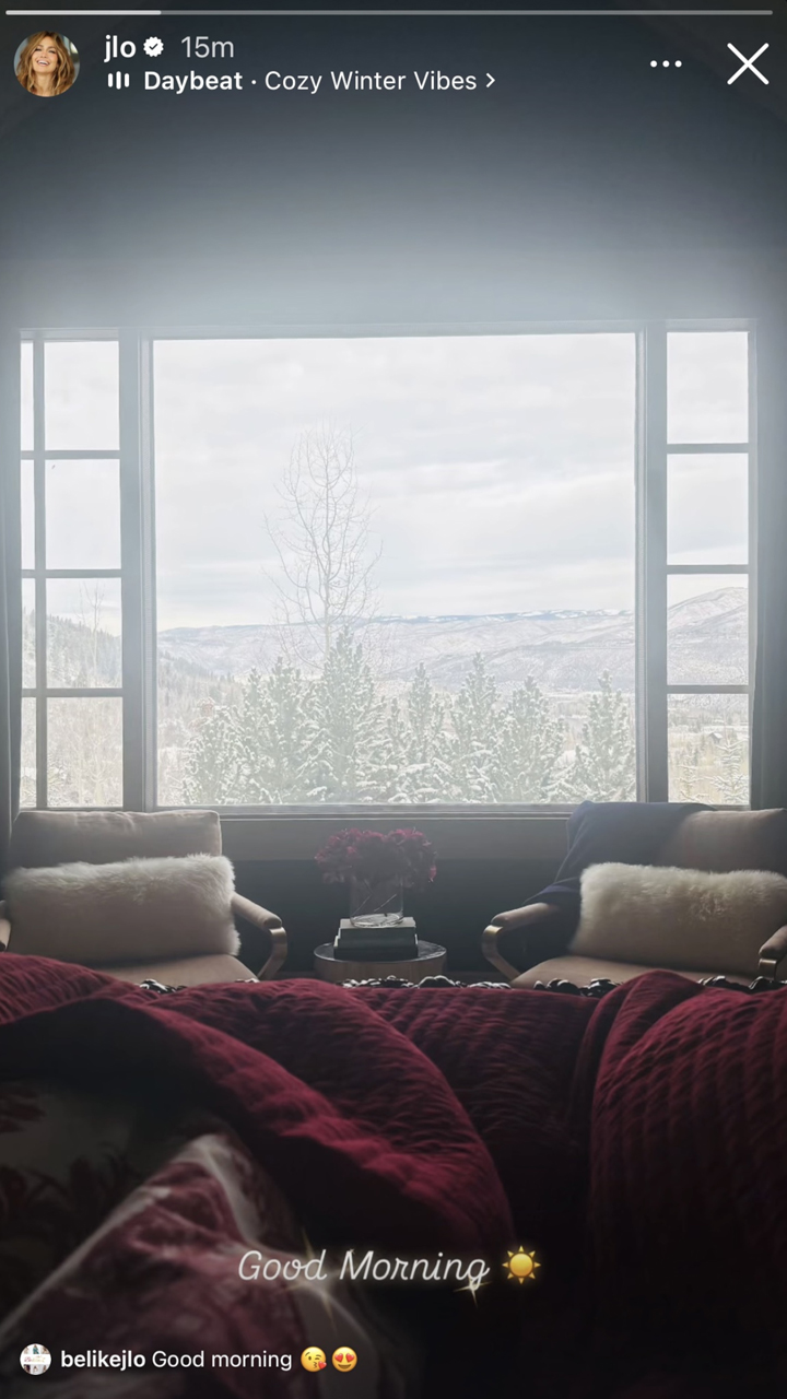 JLo shares a beautiful, serene view of her winter wonderland outside a large window as she cozies under a red blanket.