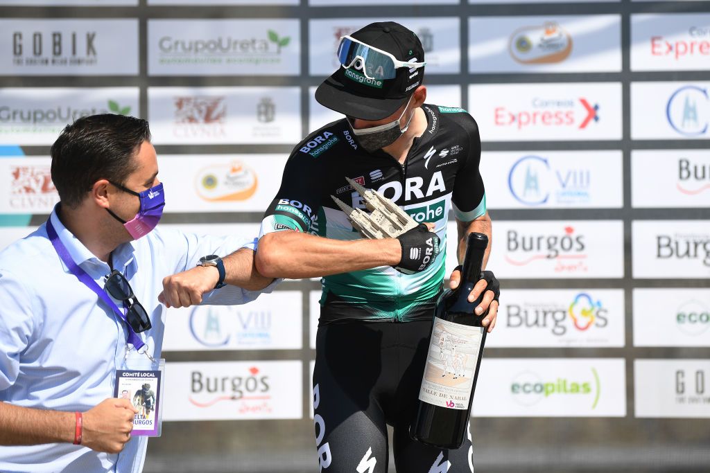 Felix Gro&szlig;schartner touches elbows instead of shaking hands on the podium at the Vuelta a Burgos