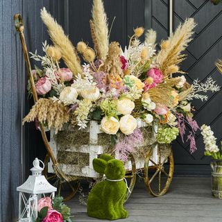 flowers in golden wheel cart with white wooden box