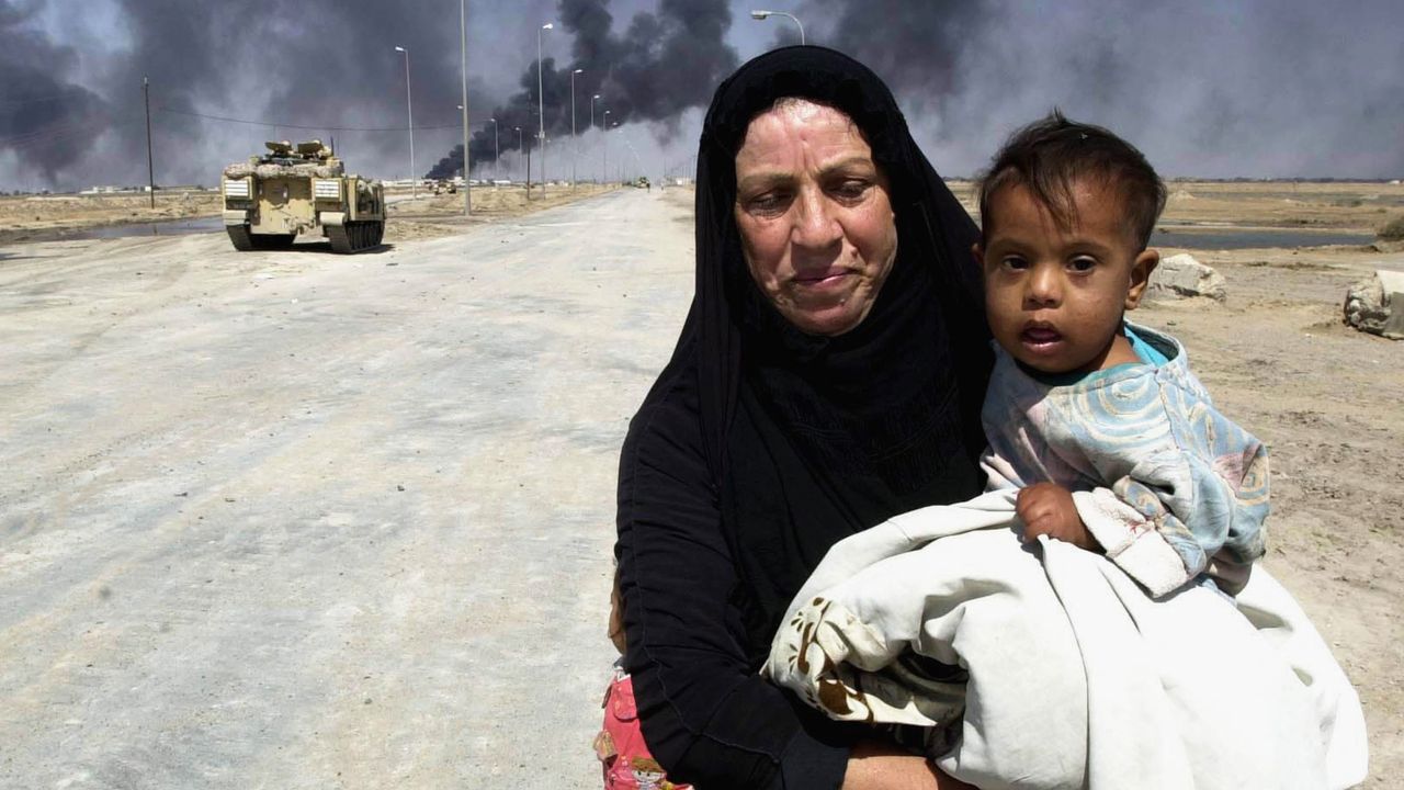 A women carries a child in the desert away from British patrol