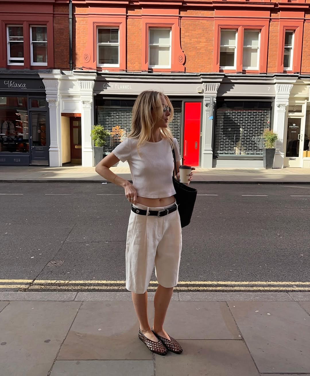 Chloe in white Bermuda shorts and black jelly flats