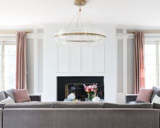 Chic living room with pink drapes and cushions, and contemporary circle ceiling pendant