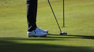 A golfer lining up a putt at Essendon Golf Club